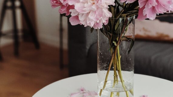 Ramo de flores rosas en un florero sobre una mesa de centro